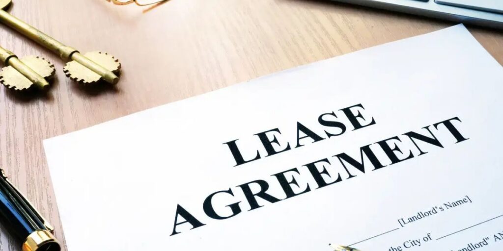 Landlord, tenant, and lease guarantor reviewing and signing a residential lease agreement together | Lease Guarantor Agreement